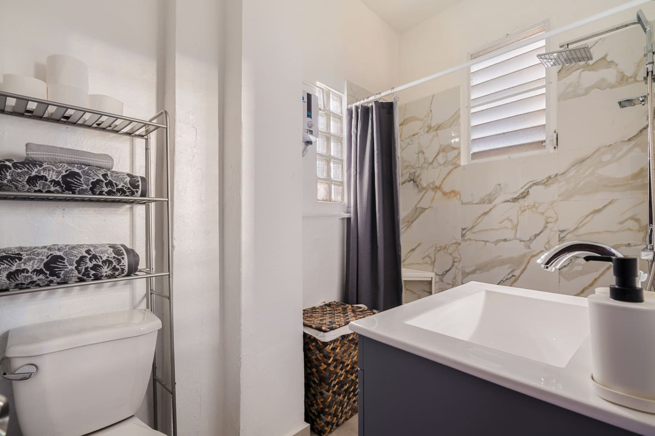 Bathroom with a toilet, sink, and shower — Tapia Mosaic Beachwalk - San Juan, Santurce