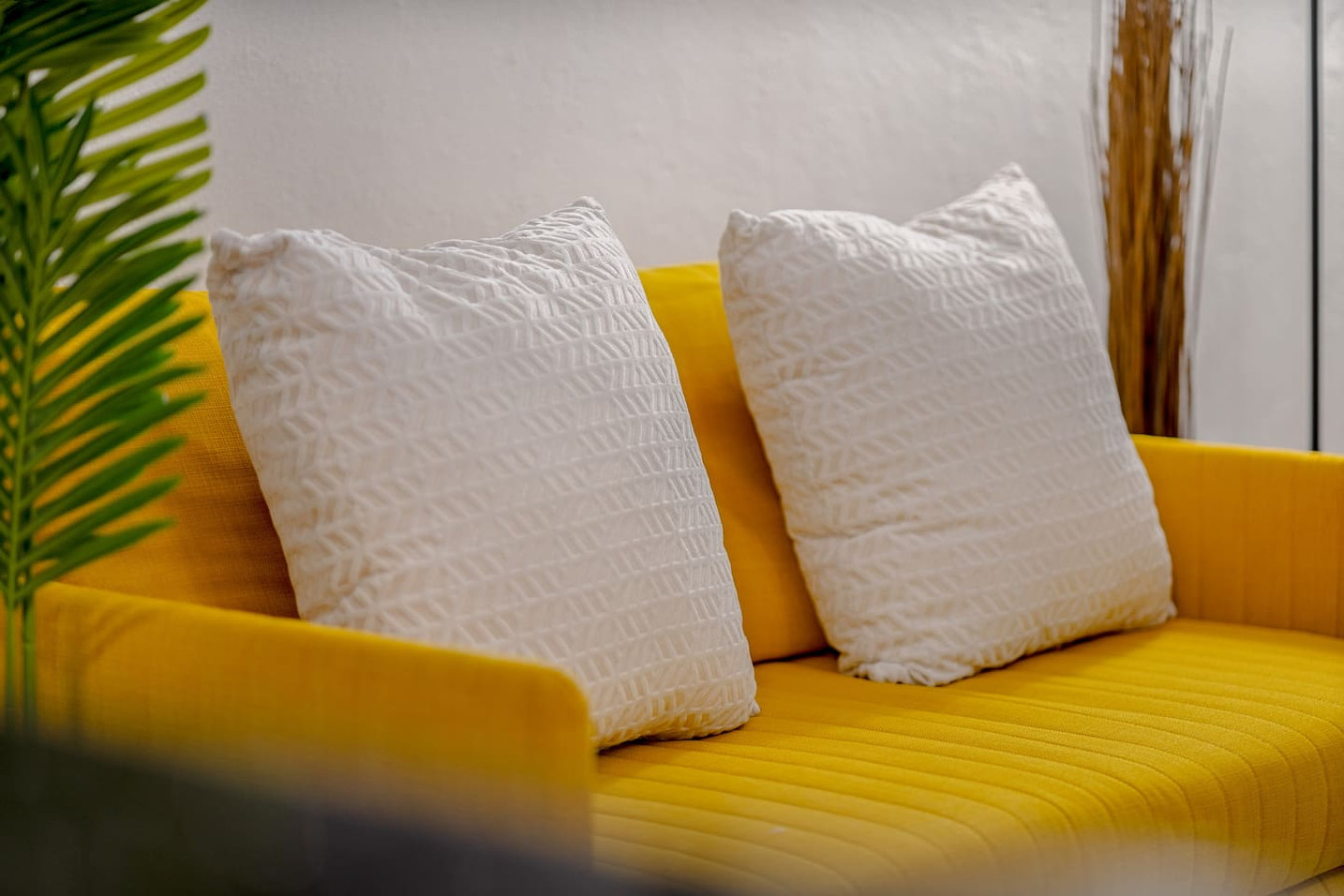 Yellow couch with white pillows and a yellow wall in the background — Loft La Luz - Old San Juan, Old San Juan