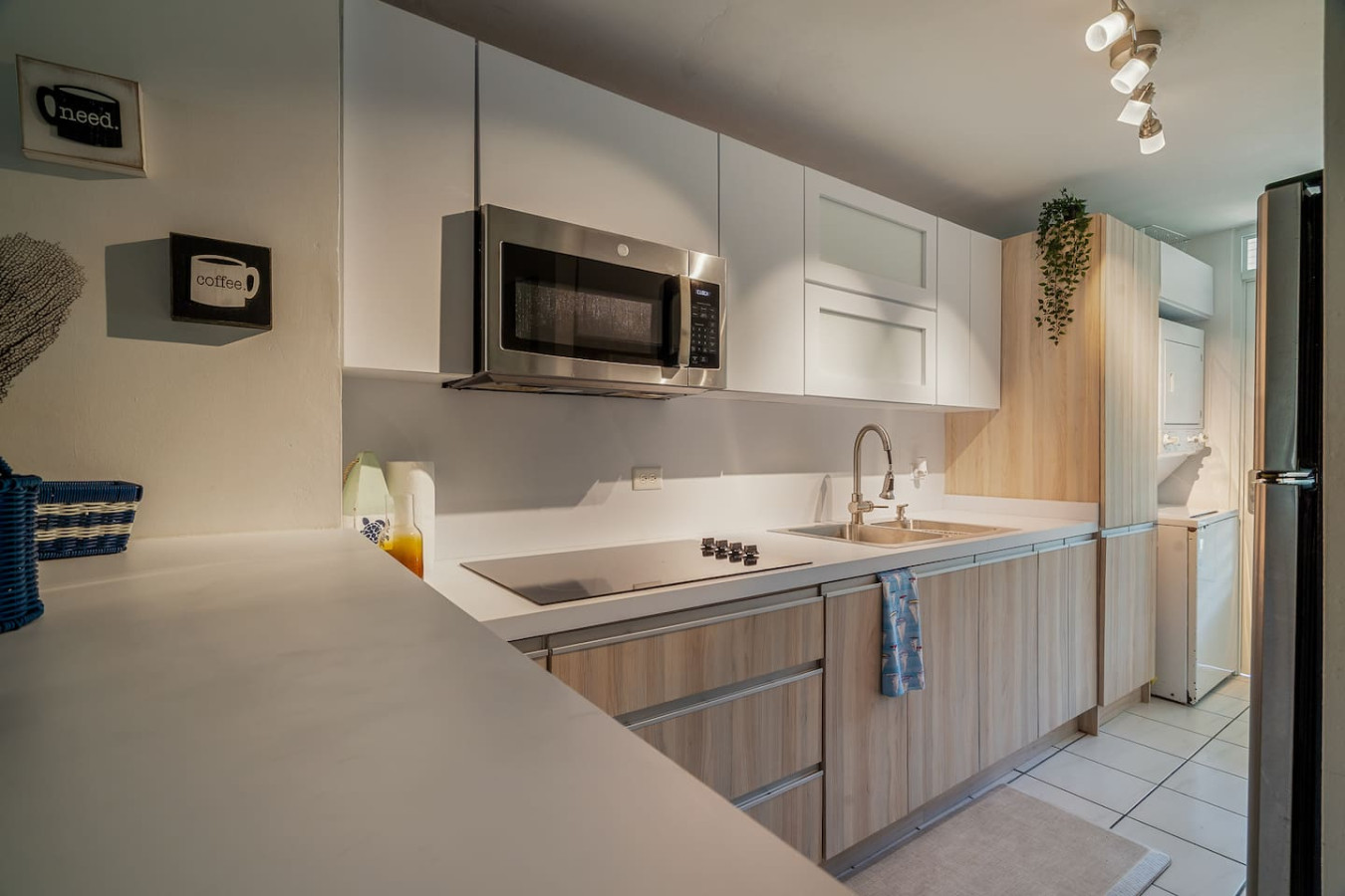 Kitchen with a cooktop, a microwave and wood cabinets — Beach Villa Dorado Del Mar