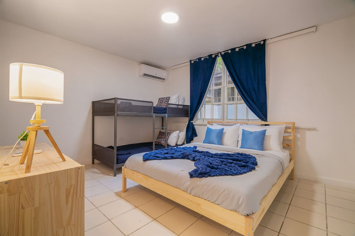 {"category": "bedroom", "alt": "A bedroom with a blue bedspread and a blue blanket on a bed — Condado Grass Patio, Santurce