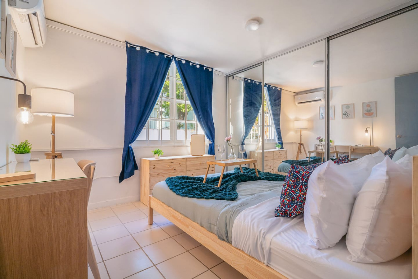 Bedroom with a bed, a chair, and a window with blue curtains — Condado Grass Patio, Santurce