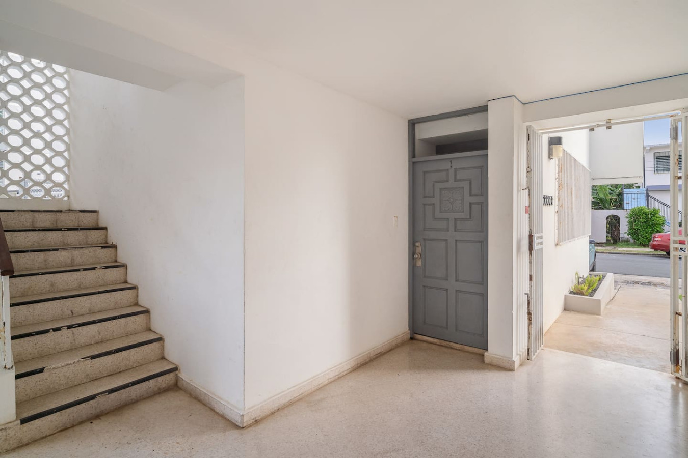 Building's entry hall with stairs and the studio door — Punta Las Marias Studio - Short Walk to the Beach, Santurce