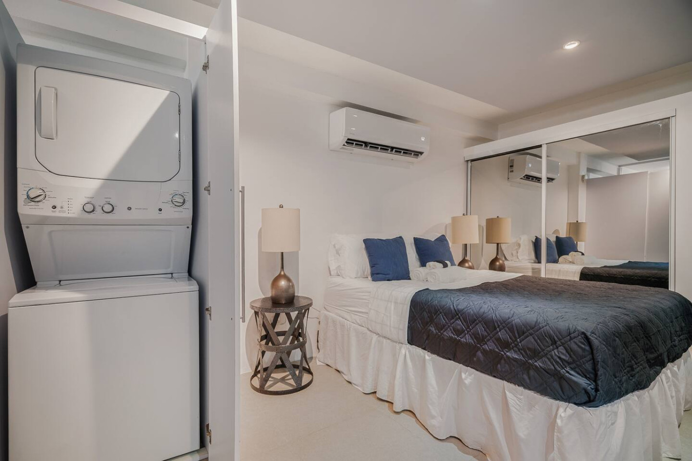 Bedroom with a bed, nightstand, and a mirrored closet door — Punta Las Marias Studio - Short Walk to the Beach, Santurce