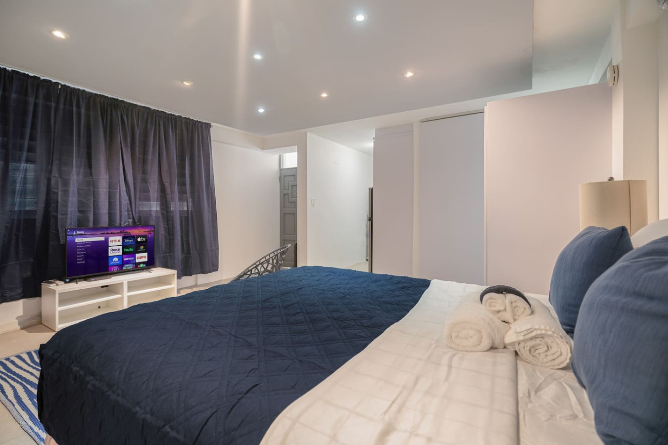 Bedroom with a blue bedspread and a flat screen TV on a table — Punta Las Marias Studio - Short Walk to the Beach, Santurce