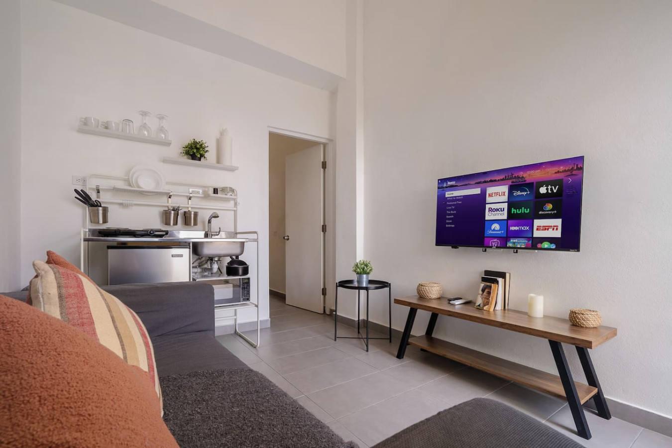 Living area with a TV console and the kitchenette — Downtown San Juan Gateway Dream, Santurce