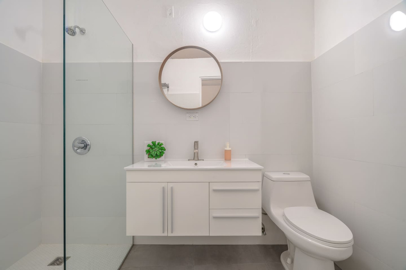 Bathroom with a white toilet and a mirror above it — Downtown San Juan Gateway Dream, Santurce