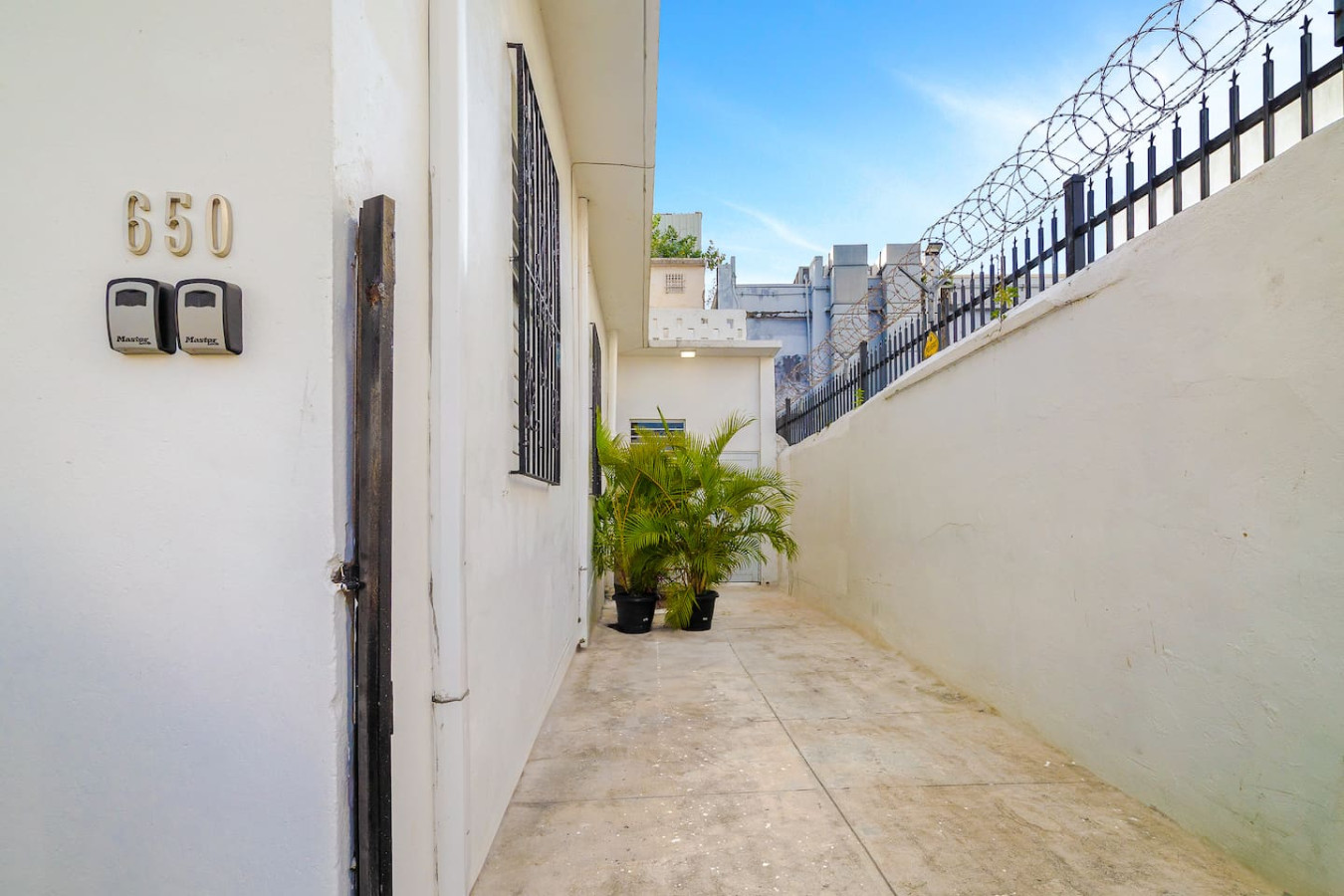 White house with a black door and a black pot on the ground — Downtown San Juan Gateway Dream, Santurce