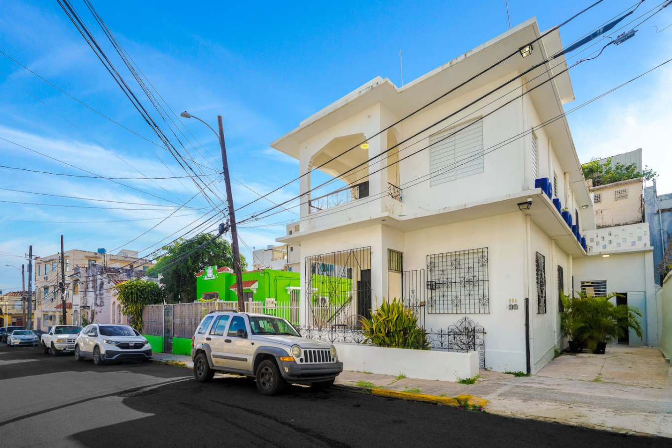 Compact SUV parked in front of a white house with a green door — Downtown San Juan Gateway Dream, Santurce