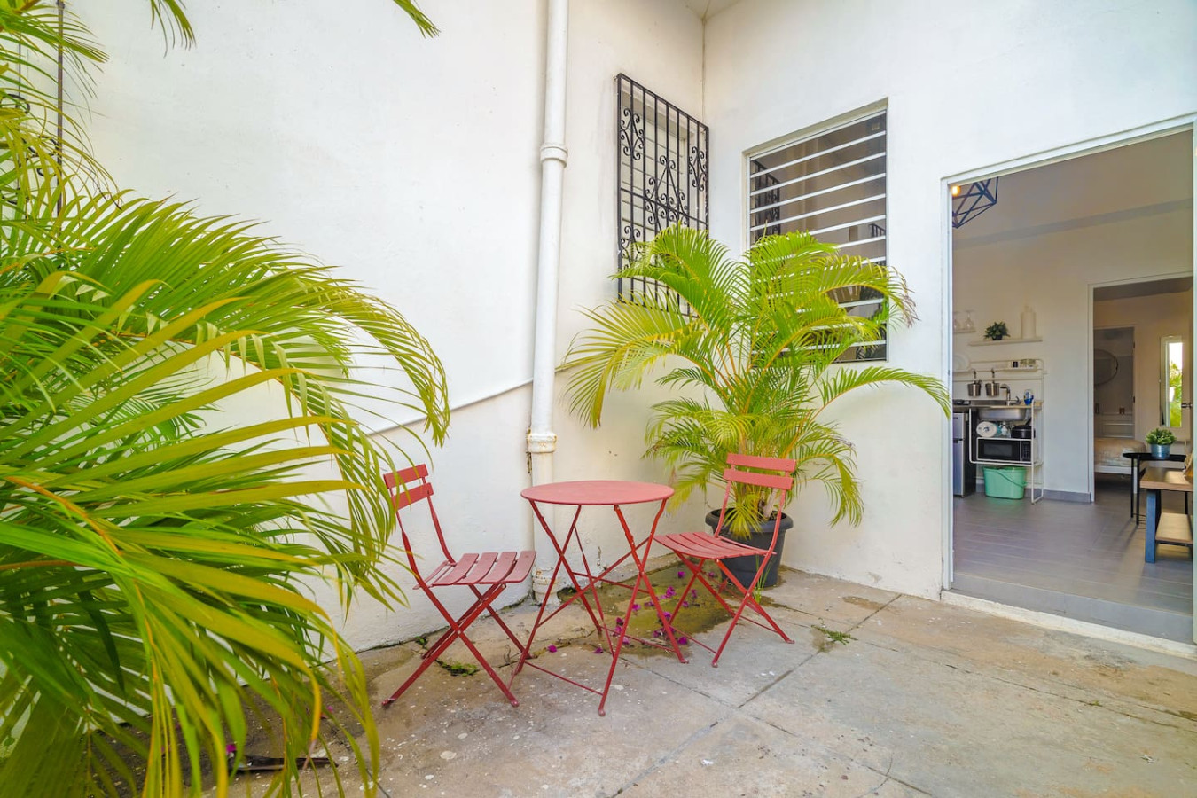 Two red chairs on a patio outside a white building — Downtown San Juan Gateway Dream, Santurce