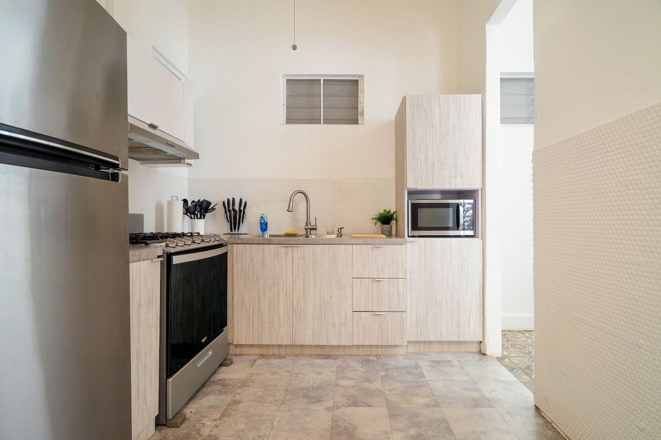 Kitchen with a gas range, sink and built-in microwave — Luz Collection No.2 – Casa Brisa | 3BR Retreat, Santurce