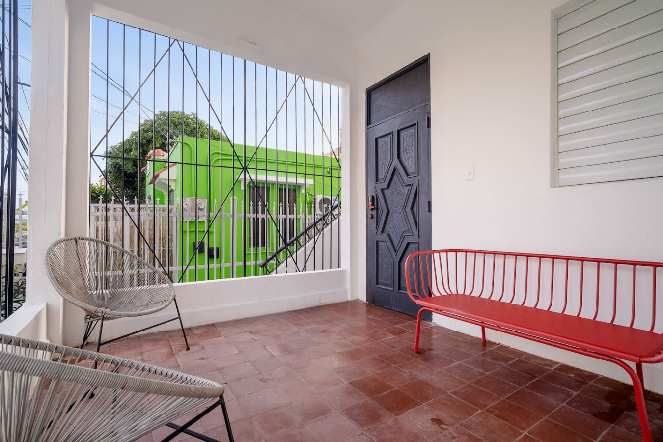 Green bus parked in front of a house — Luz Collection No.2 – Casa Brisa | 3BR Retreat, Santurce