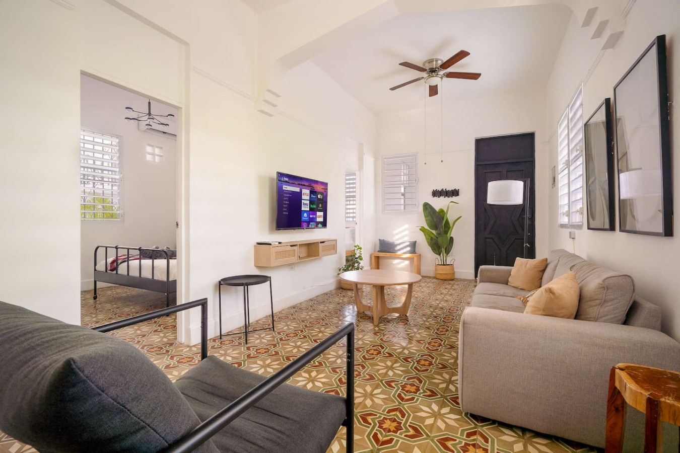 Living room with a flat screen TV and a potted plant — Luz Collection No.2 – Casa Brisa | 3BR Retreat, Santurce