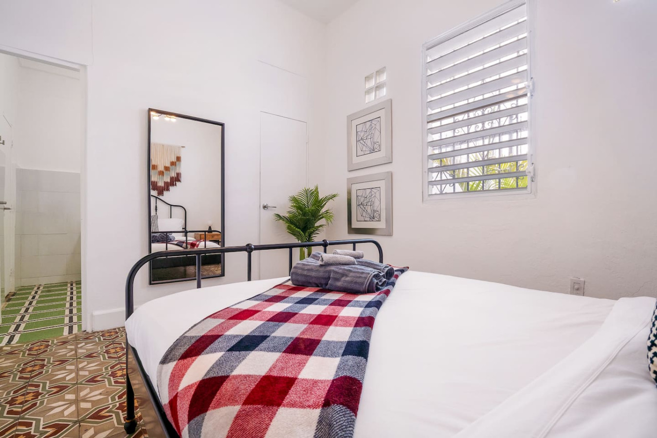 Bedroom with a bed, a mirror, and a plant — Luz Collection No.2 – Casa Brisa | 3BR Retreat, Santurce
