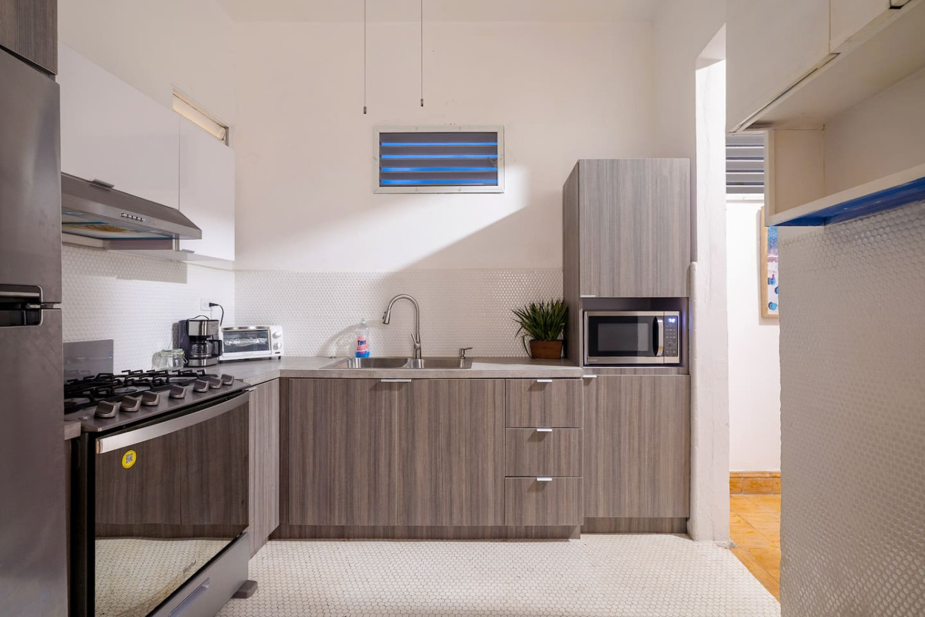 Kitchen with a gas range, a sink and a microwave — Luz Collection No.3 – Casa Horizonte | 3BR Loft, Santurce