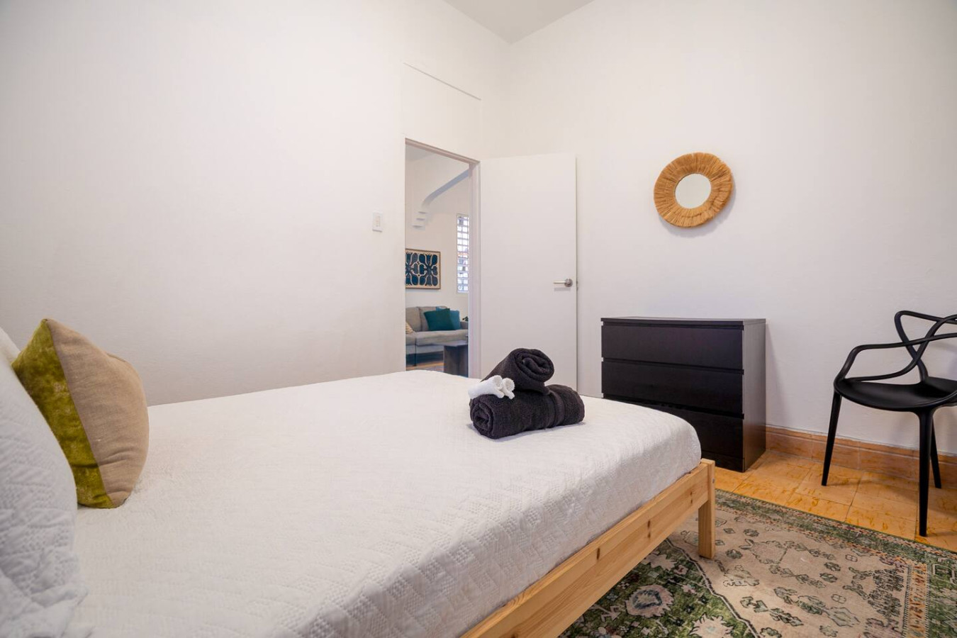 Bedroom with a white bed and a black and brown blanket on it — Luz Collection No.3 – Casa Horizonte | 3BR Loft, Santurce