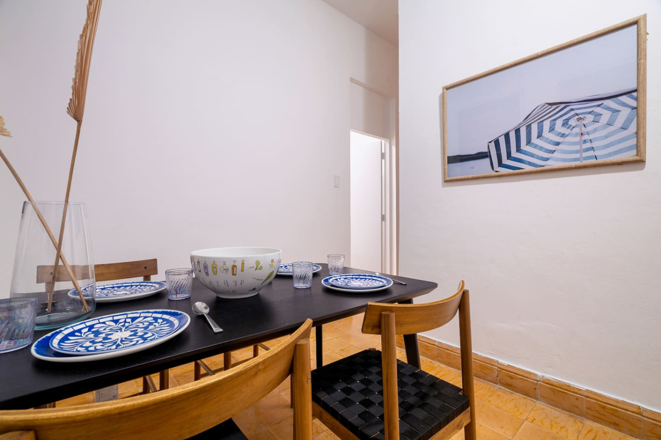 Dining corner with a set table and an umbrella print — Luz Collection No.3 – Casa Horizonte | 3BR Loft, Santurce