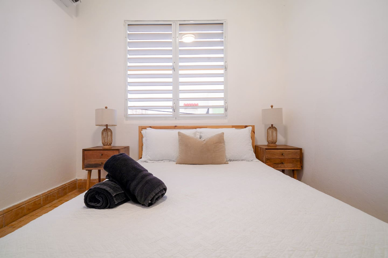 Bedroom with a bed and a black blanket on it — Luz Collection No.3 – Casa Horizonte | 3BR Loft, Santurce