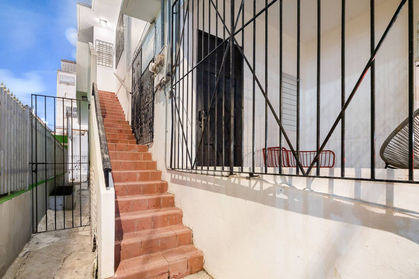Building's outdoor staircase and iron gate — Luz Collection No.3 – Casa Horizonte | 3BR Loft, Santurce