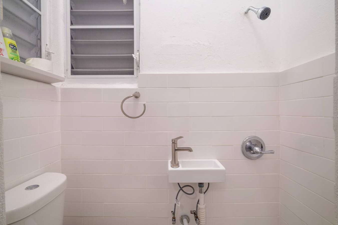 Bathroom with a wall-mounted sink, a toilet and a shower — Luz Collection No.3 – Casa Horizonte | 3BR Loft, Santurce