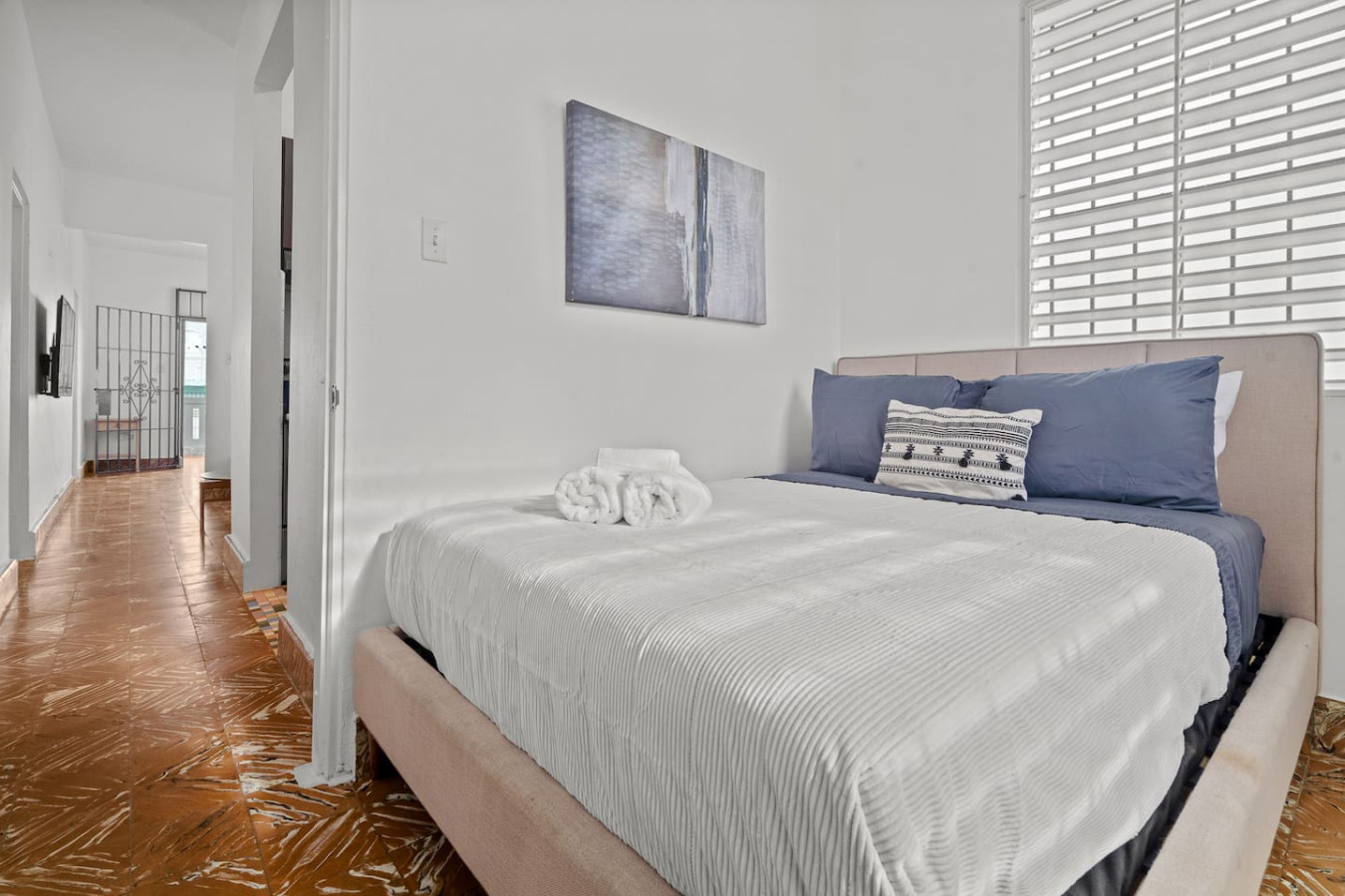 Bedroom with a white bedspread and a painting on the wall — Sunkiss in puerto Rico San Juan 3 Bedroom, Santurce