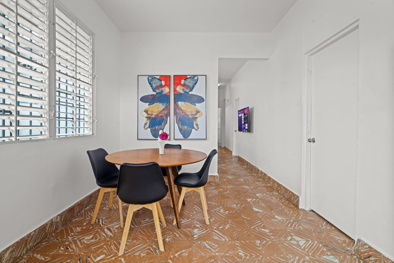 Dining table with chairs and a vase of flowers on it — Sunkiss in Puerto Rico San Juan 3 Bedroom, Santurce