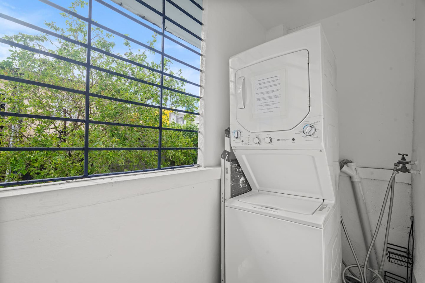 Stacked washer and dryer by a window — Sunkiss in Puerto Rico San Juan 3 Bedroom, Santurce