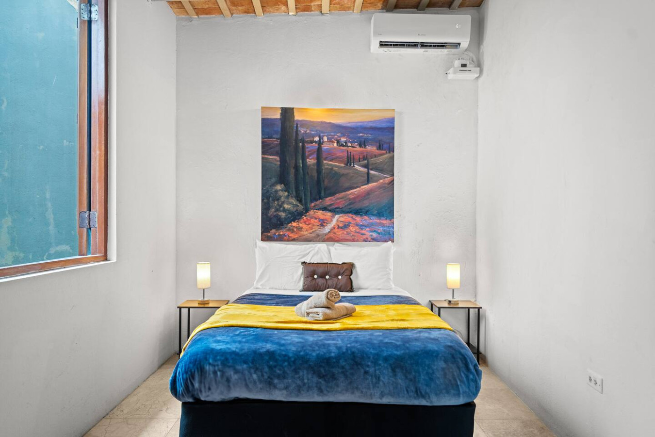 Bedroom with a blue bedspread and a painting on the wall — Royal Imperial | Balcony Private | Old San Juan, Old San Juan