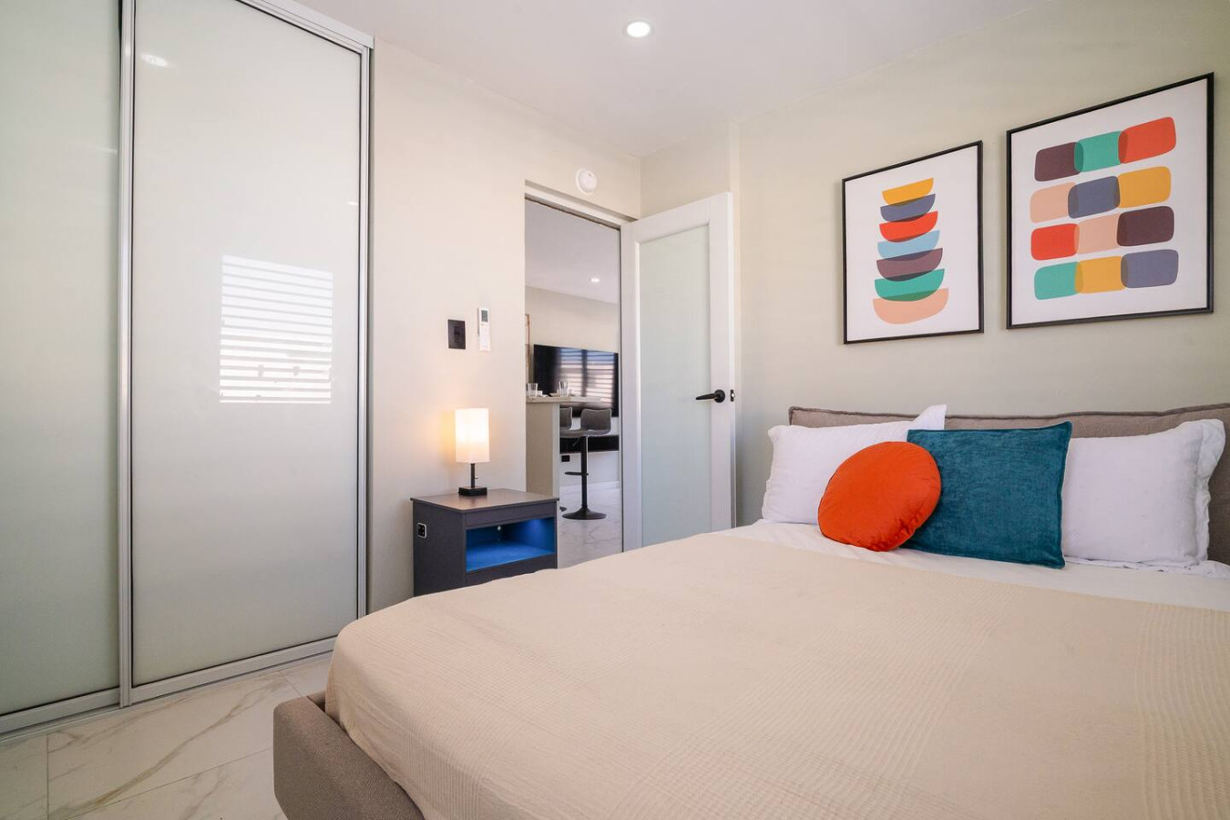 Bedroom with a bed, a lamp, and a painting on the wall — SunJoy Modern 2BR Apartment Isla Verde, Carolina