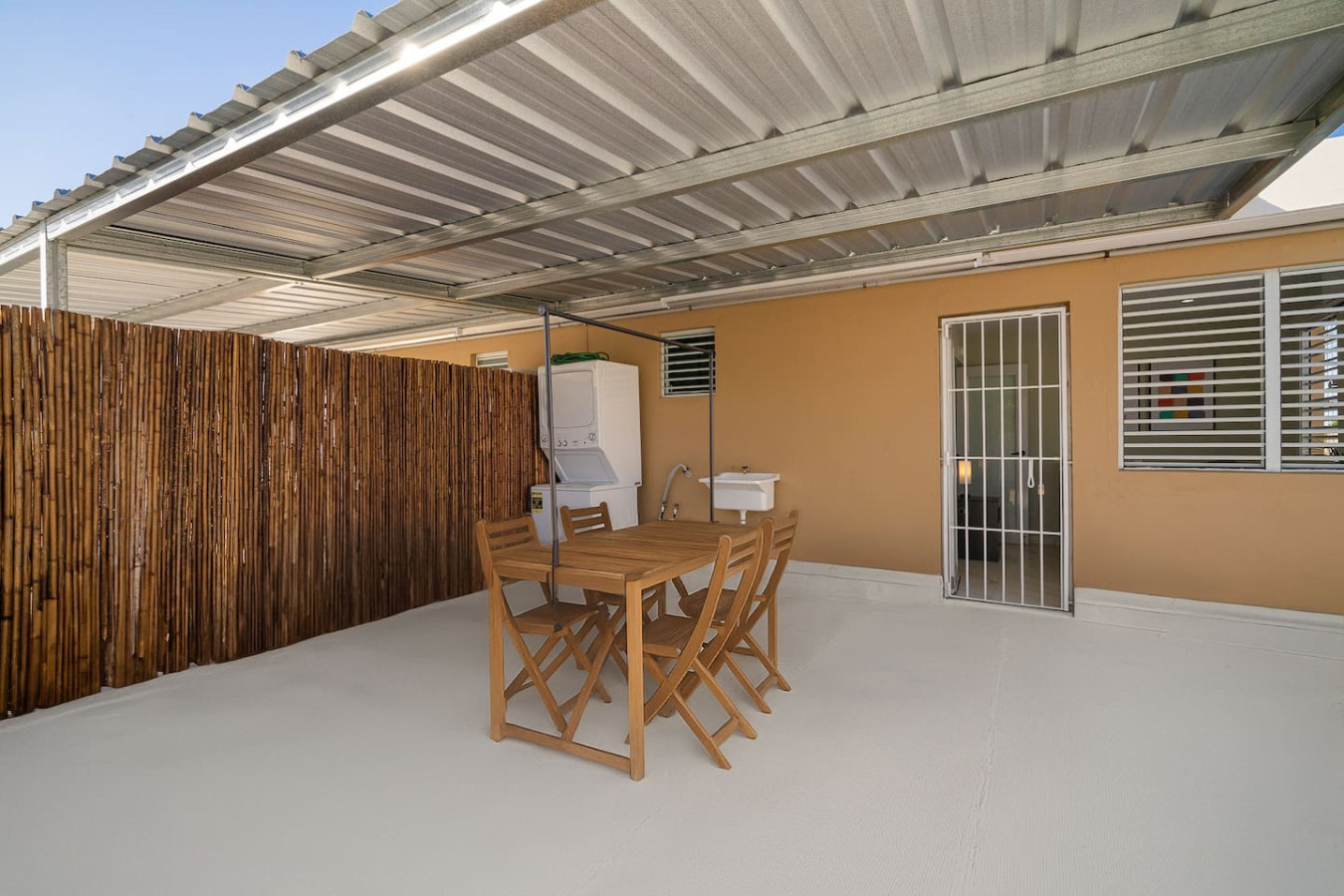 Wooden dining table with chairs in a patio — SunJoy Modern 2BR Apartment Isla Verde, Carolina