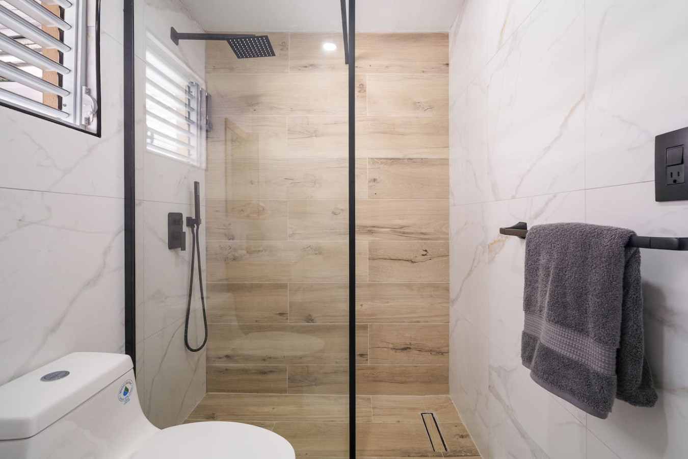 Bathroom with a walk-in shower and wood-look tile — SunJoy Modern 2BR Apartment Isla Verde, Carolina