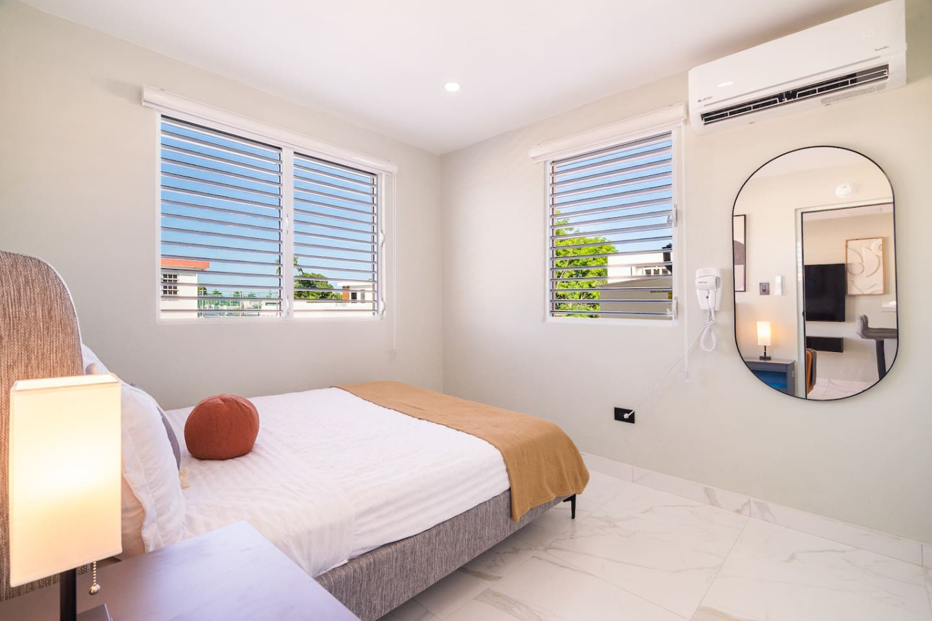 Bedroom with a bed and a mirror — SunJoy Modern 2BR Apartment Isla Verde, Carolina