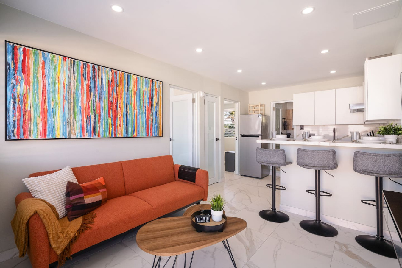 Living room with a couch and a painting on the wall — SunJoy Modern 2BR Apartment Isla Verde, Carolina