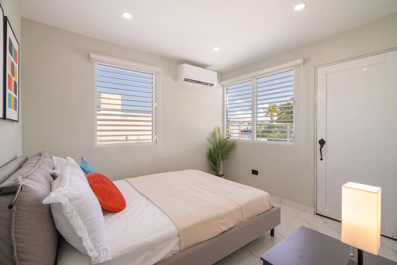 Bedroom with a bed, a potted plant, and a window — SunJoy Modern 2BR Apartment Isla Verde, Carolina