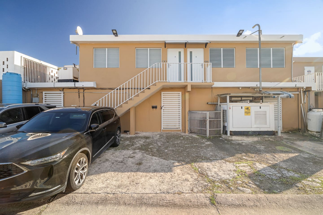 Black car parked in front of a house — SunJoy Modern 2BR Apartment Isla Verde, Carolina