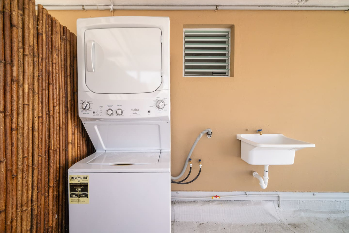 Stacked washer and dryer on the covered patio — SunJoy Modern 2BR Apartment Isla Verde, Carolina