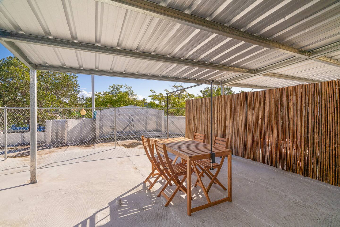 Patio table with chairs under a metal roof — SunJoy Modern 2BR Apartment Isla Verde, Carolina