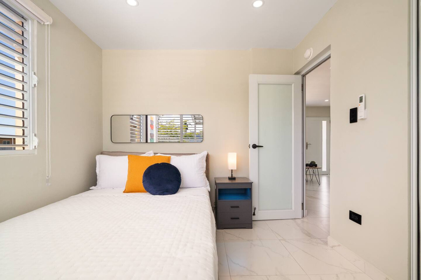 Bedroom with a bed, a mirror, and a lamp — MoonJoy Chic 2BR Apartment Private Patio, Carolina
