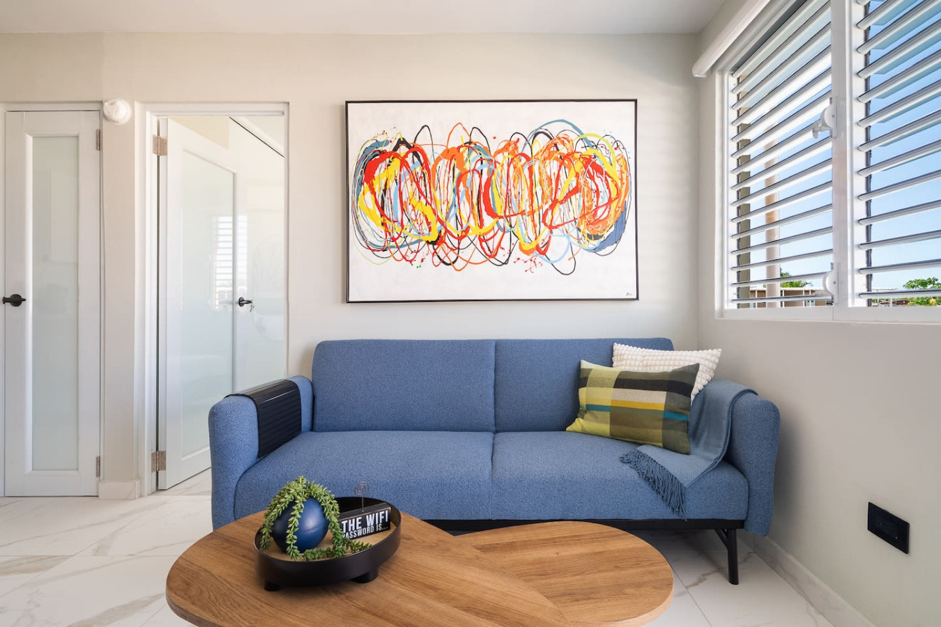 Blue couch with a large painting above it — MoonJoy Chic 2BR Apartment Private Patio, Carolina