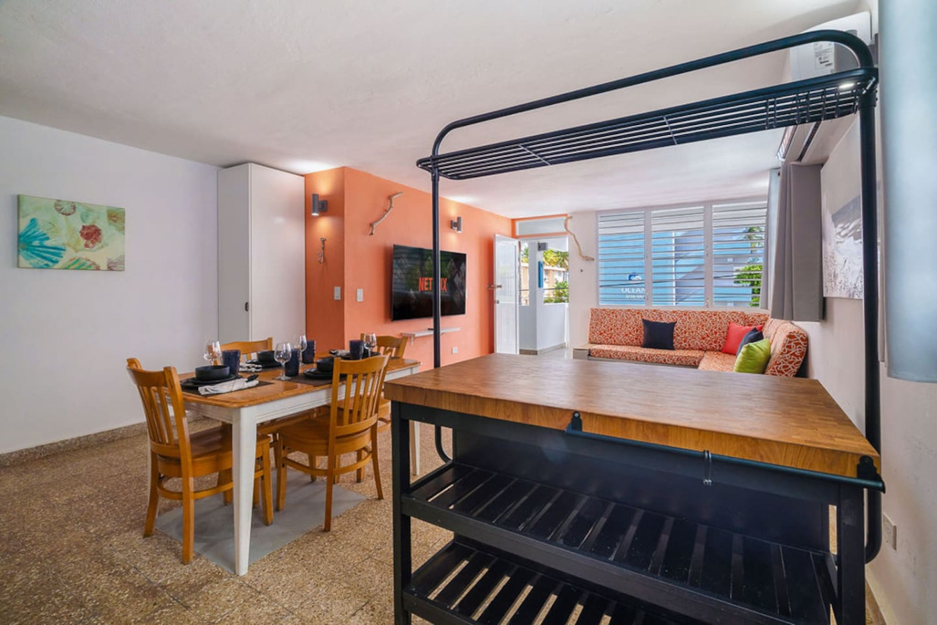 Dining room table with chairs and a TV in the background — Walking to the Beach 3 bedroom House Next to Ocean, Luquillo