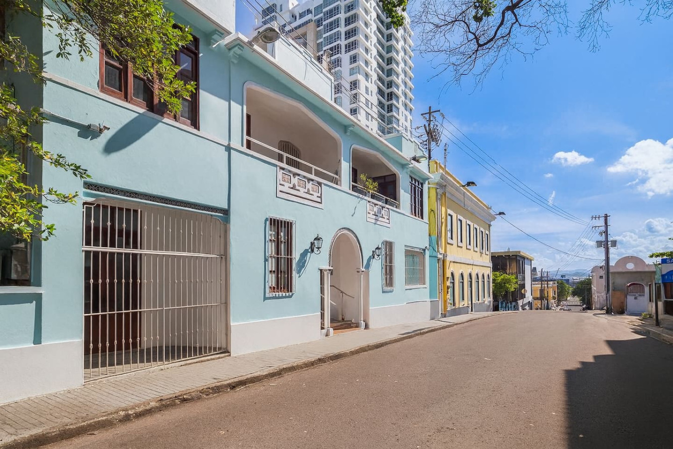 Blue and white building with a balcony and a yellow door — Historical Old SanJuan Spanish style private Patio, San Juan