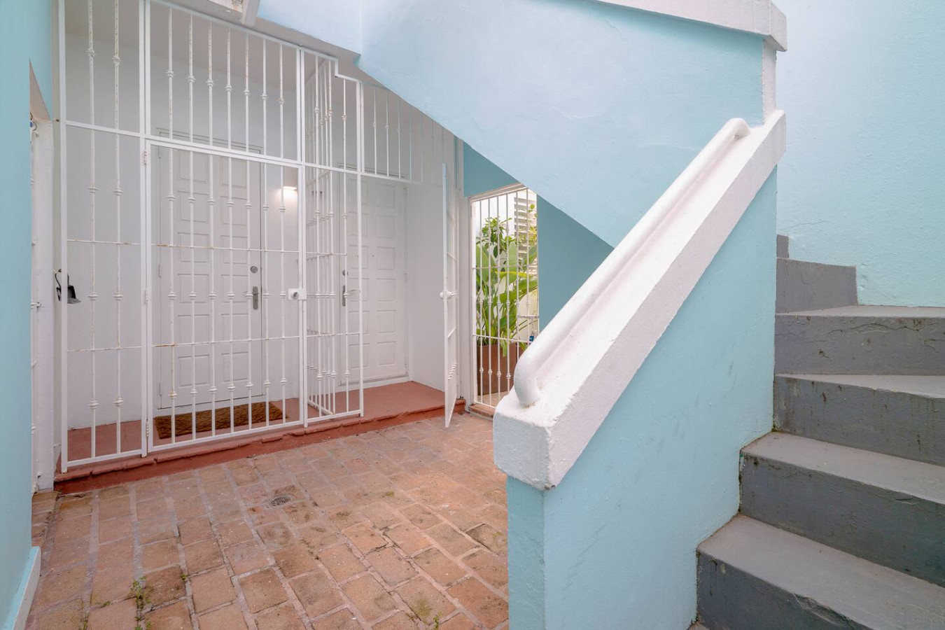 Building's entry with a white iron gate and stairs — Historical Old San Juan Spanish style private Patio