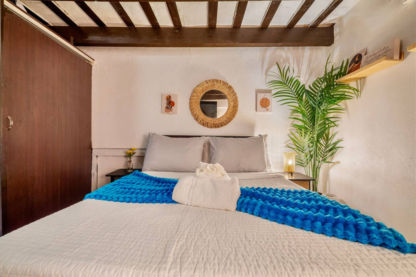 Bedroom with a blue comforter and a white towel on it — La Cueva Loft Rustic Colonial Romance, Old San Juan