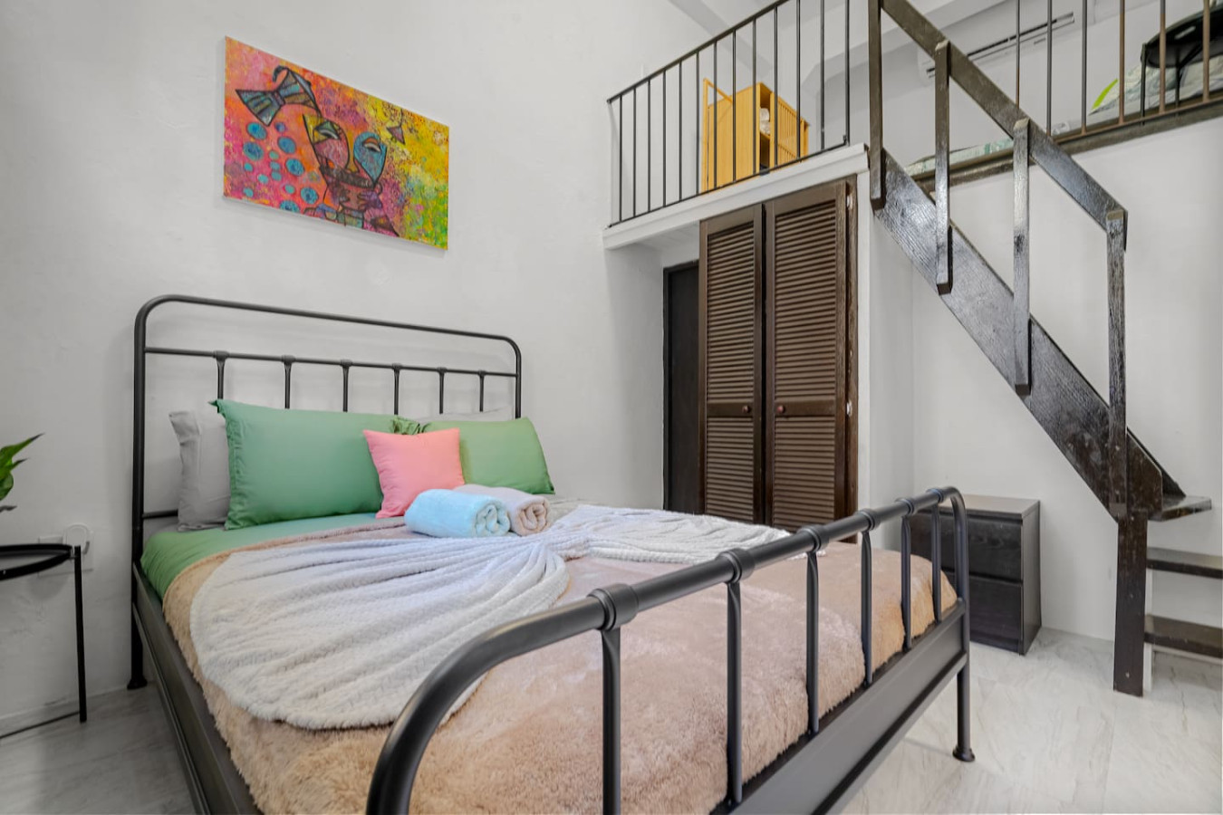 Bedroom with a bed, a painting on the wall, and a window — El Balcón Art Loft – Old San Juan, Old San Juan