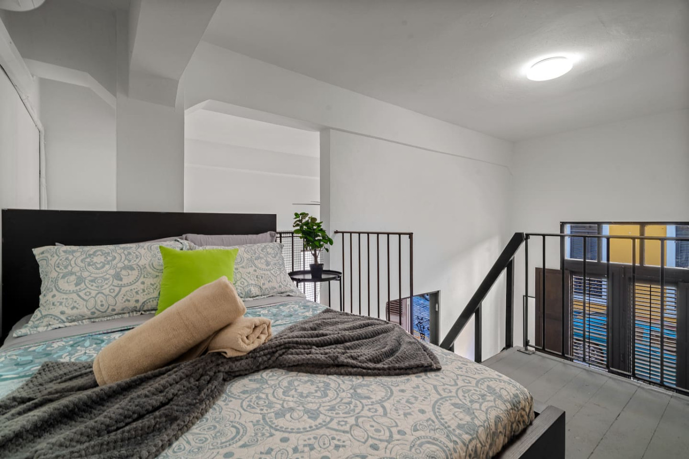 Bedroom with a bed and a potted plant on a balcony — El Balcón Art Loft – Old San Juan, Old San Juan