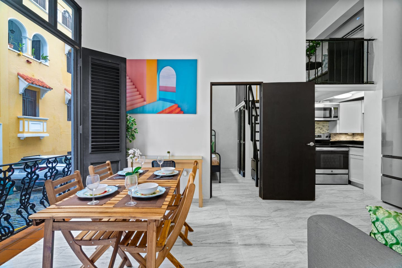 Dining room table with chairs and a vase of flowers on it — El Balcón Art Loft – Old San Juan, Old San Juan