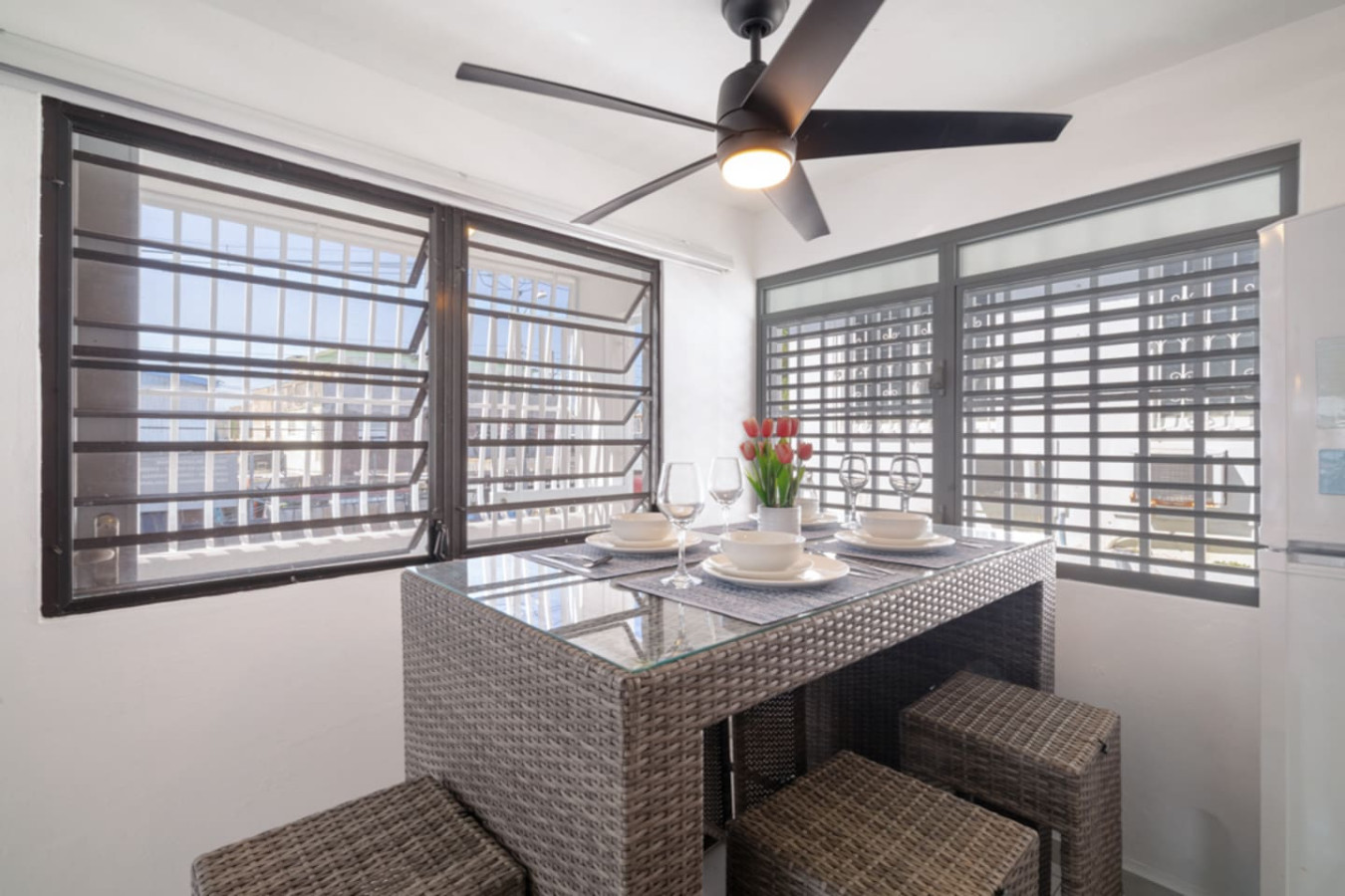 Dining table with chairs and a vase of flowers on it — Casa Juno Grand Modern - 3 Bedroom - Walk to Beach, Santurce