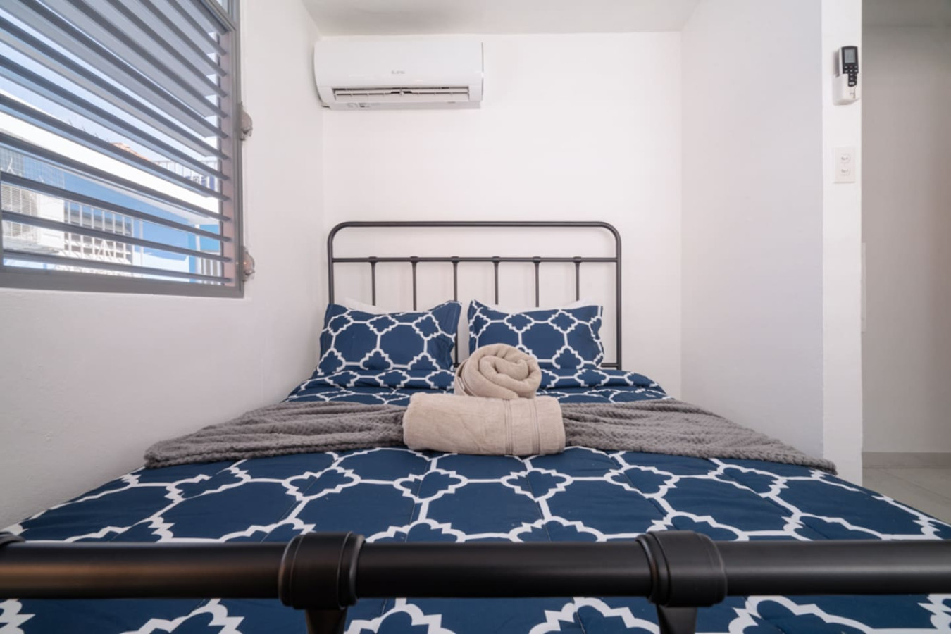 Bedroom with a black metal headboard and a blue bedspread — Casa Juno Grand Modern - 3 Bedroom - Walk to Beach, Santurce