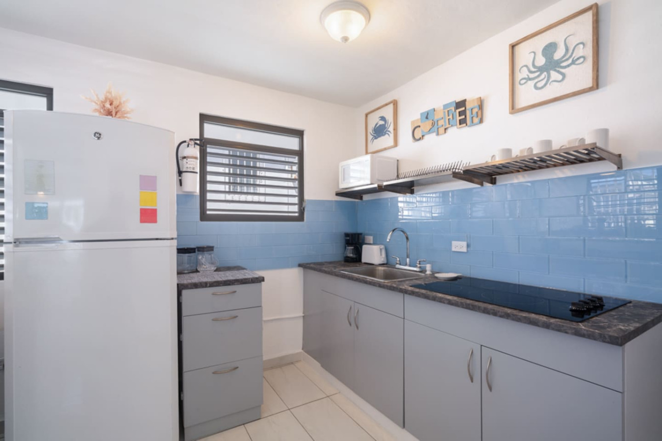 Kitchen with a refrigerator, sink, and blue tiles — Casa Juno Grand Modern - 3 Bedroom - Walk to Beach, Santurce