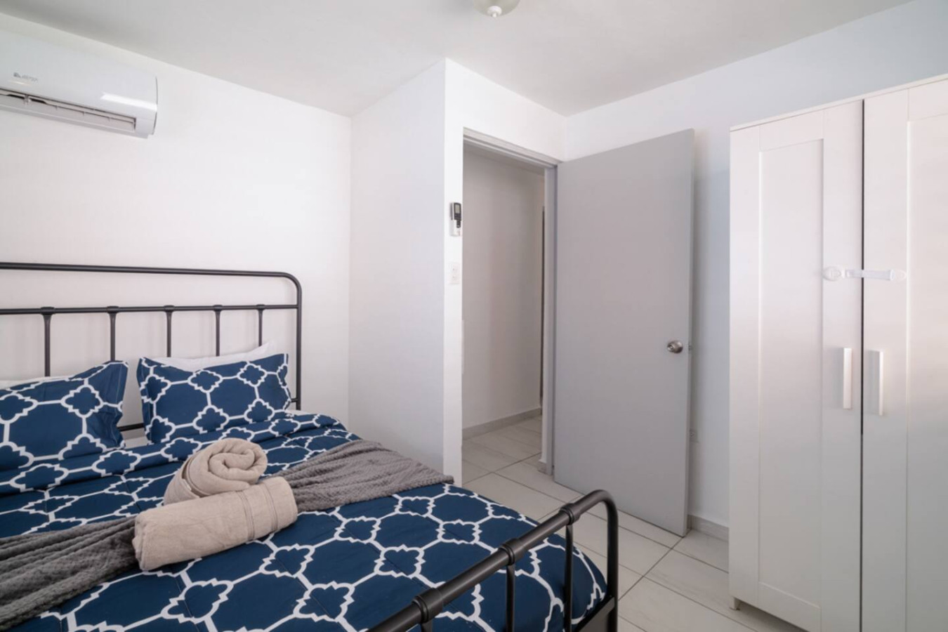 Bedroom with a blue bedspread and a black headboard — Casa Juno Grand Modern - 3 Bedroom - Walk to Beach, Santurce