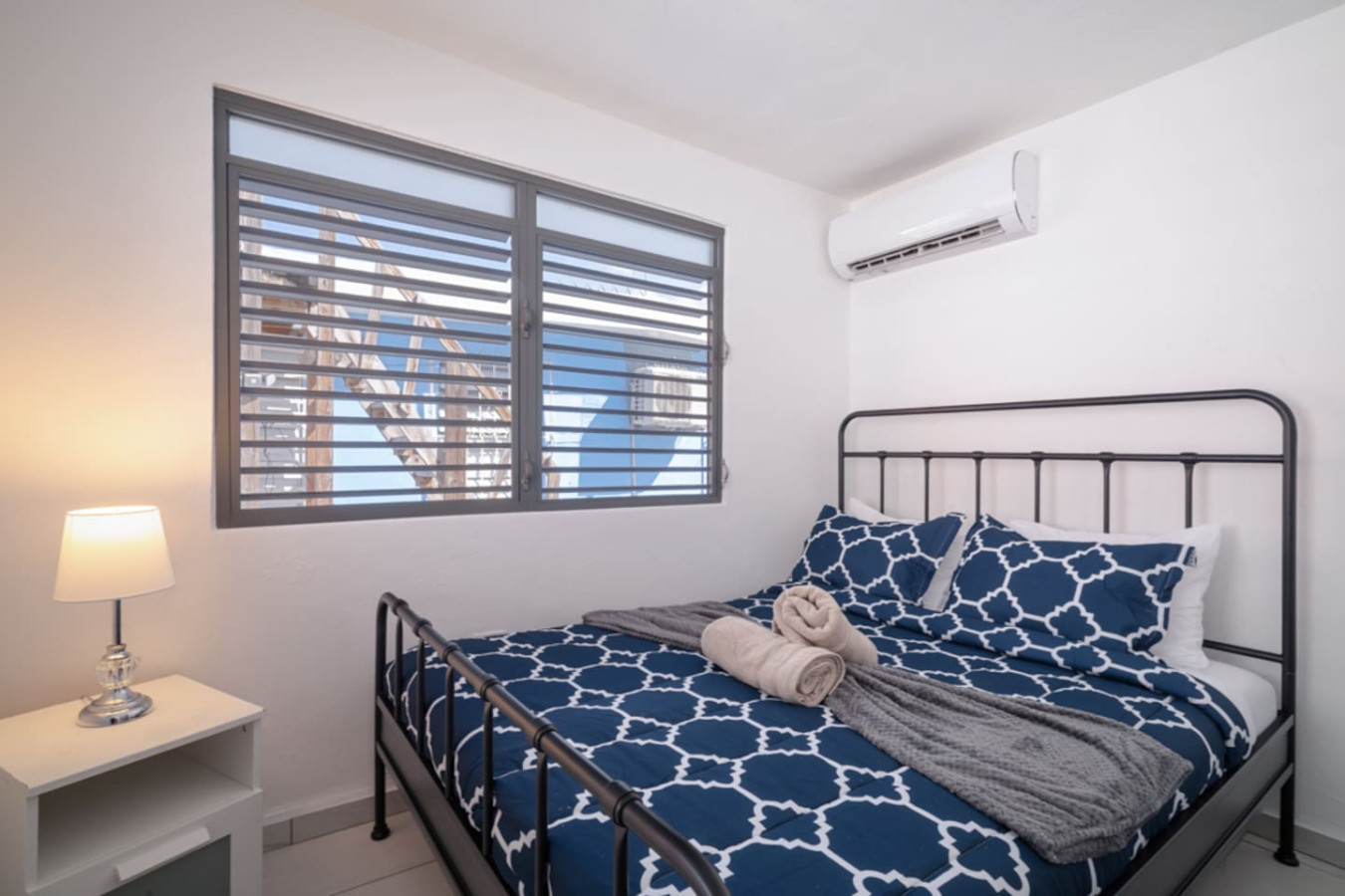 Bedroom with a blue bedspread and a view of the ocean — Casa Juno Grand Modern - 3 Bedroom - Walk to Beach, Santurce
